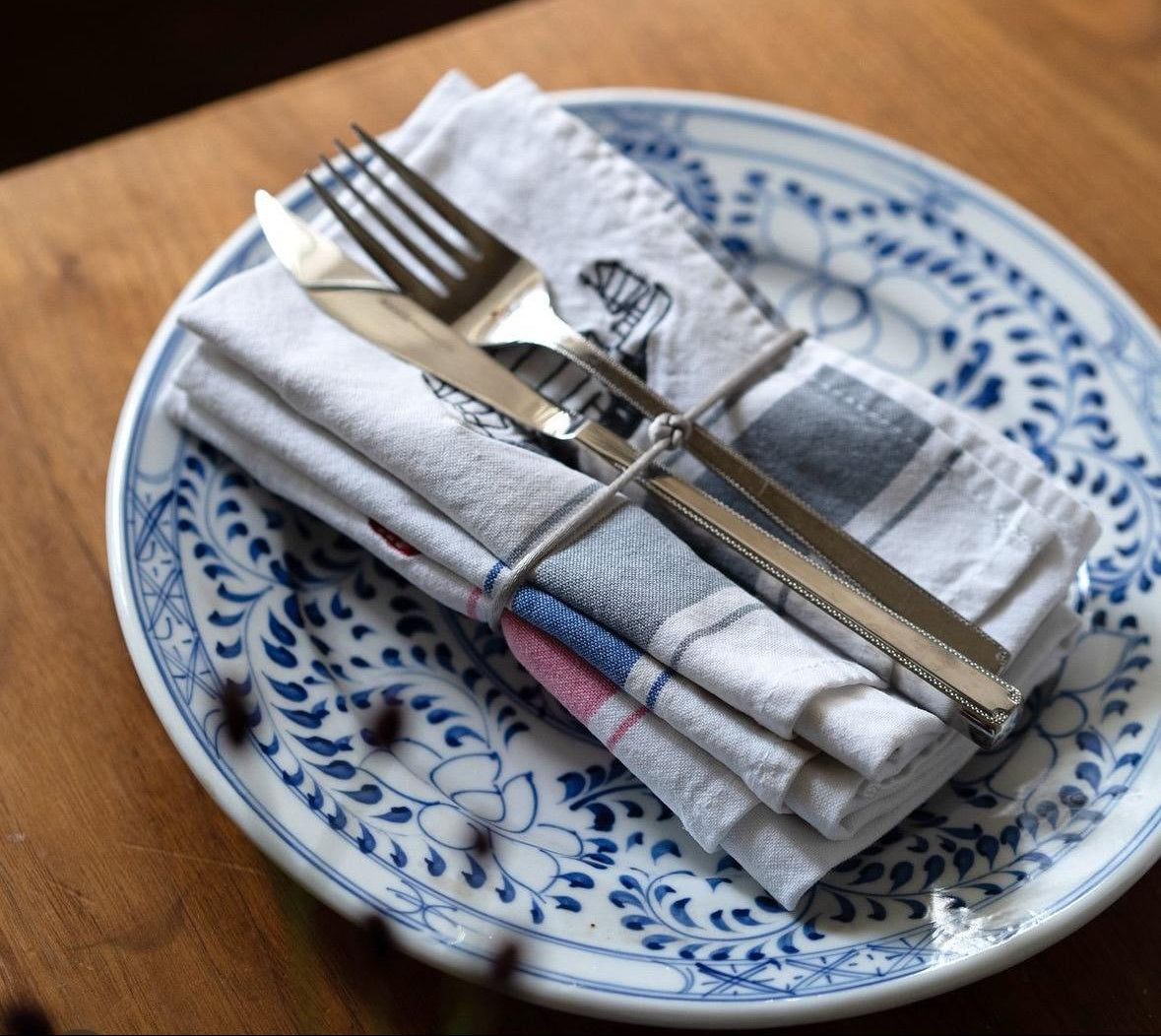 Napkins with embroidered Asian symbols, on a plate with cutlery